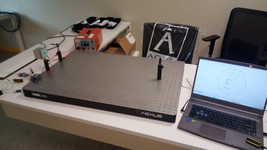 Mesa de laboratorio con equipos de óptica y portátil en demostrador del CITIUS
